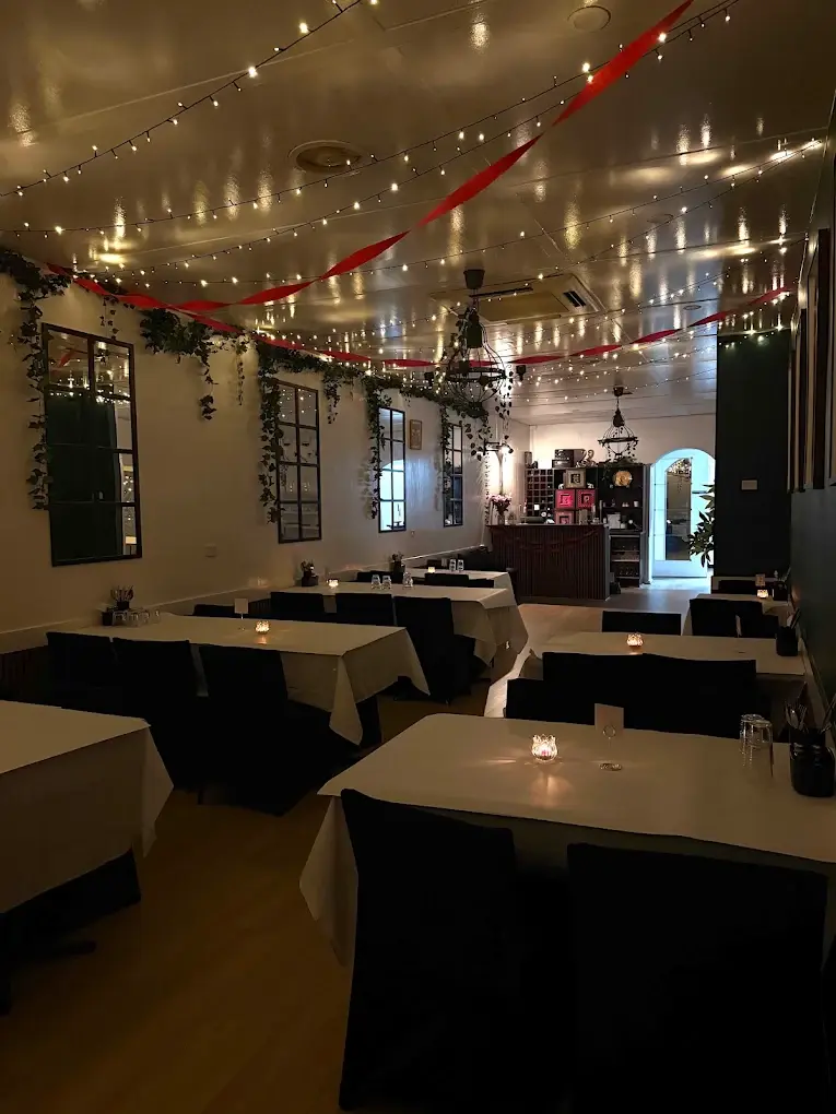 The warmly lit dining room at āhāra Dining